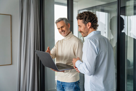 Two men having a business meeting with a laptop in an office