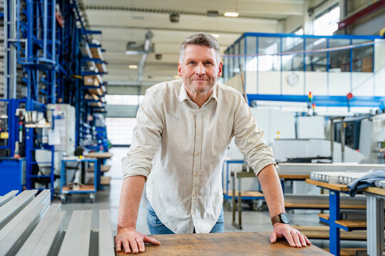 Smiling manager standing in a production hall