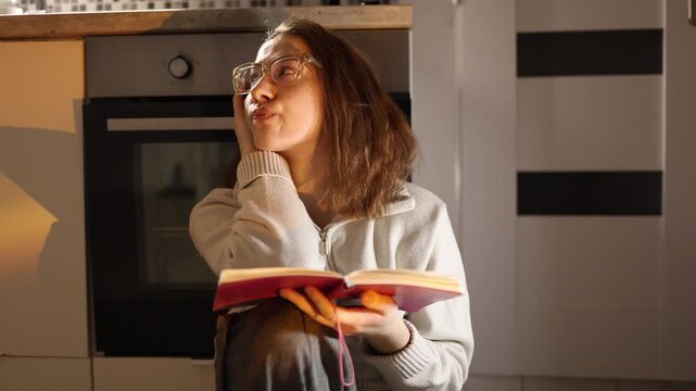 Young woman holding notebook feeling overwhelmed and unable to focus on study constantly distracted and mentally tired struggling with concentration in warm evening home atmosphere