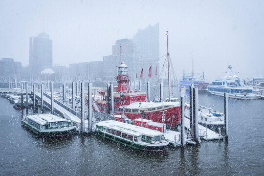 Snowy harbor in Hamburg with lightship and Elbphilharmonie