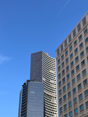 Fototapeta premium Modern geometric skyscraper with blue sky, minimal urban architecture