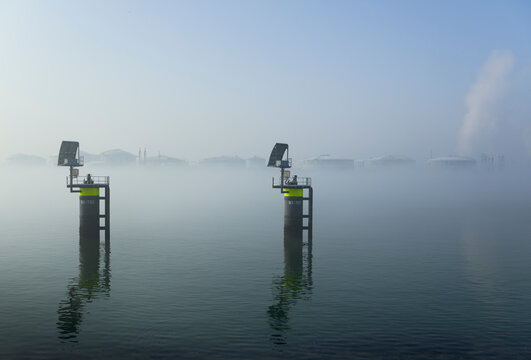 Oil storage tanks in fog at Rotterdam harbour in the Netherlands
