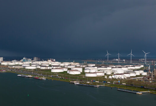 Oil storage at Rotterdam harbor with dark stormy clouds approaching