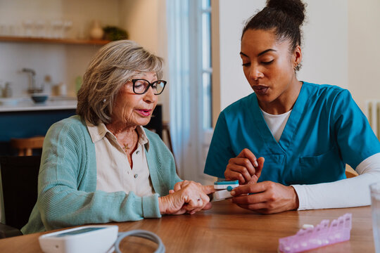 Nurse monitoring oxygen saturation with pulse oximeter at home