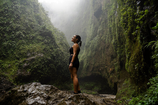 Hiker exploring Tumpak Sewu Waterfall jungle in Java Indonesia