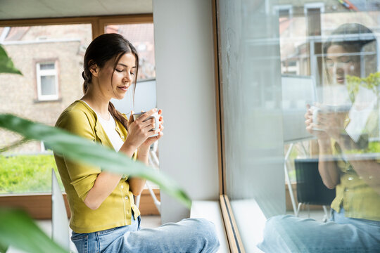 Young businesswoman having coffee at modern work place