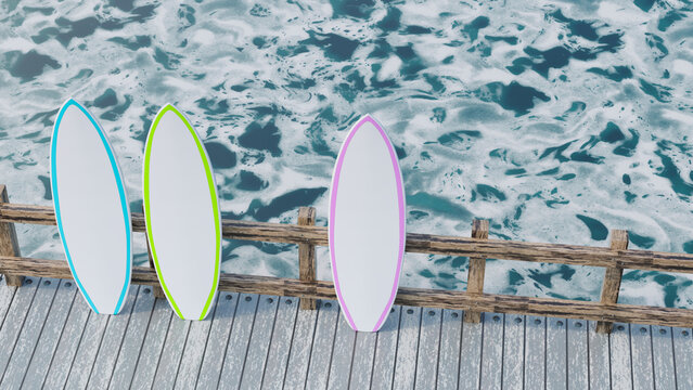 Three surfboards leaning on a wooden dock over the ocean in summer