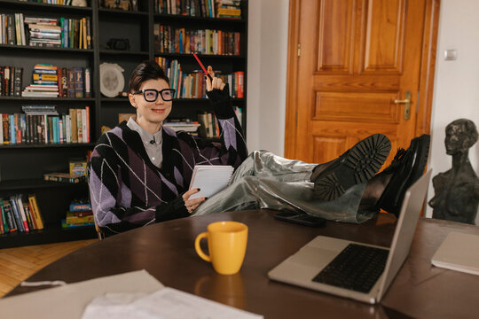 Creative director thinking with feet on desk in modern apartment