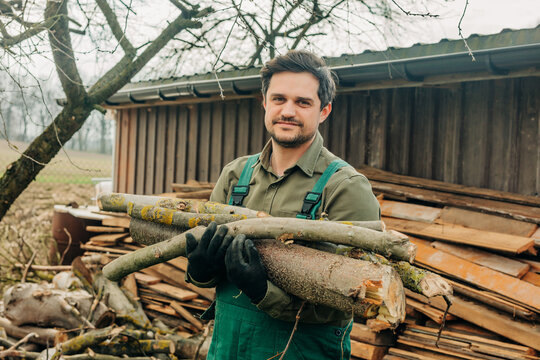 Gardener carrying cut wood and timber outdoors in spring
