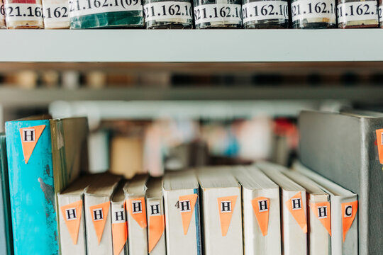 Books on shelves in a public library with classification labels