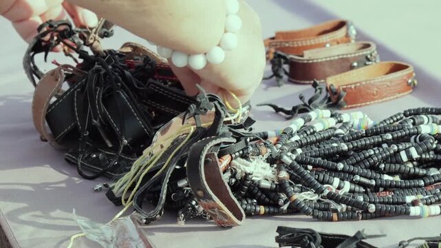 Chaotic yet captivating mix of leather accessories and vibrant beaded necklaces. The earthy tones of the leather contrast with the bold patterns of the beads, creating a sense of free-spirited creativ