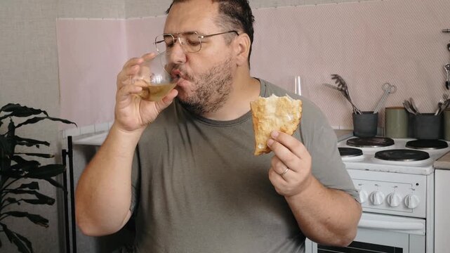 A man eats a triangular pie, samsa or echpochmak in a cafe