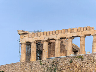 Obraz premium Partial horizontal view of the Parthenon on the Acropolis in Athens, Greece, showing ancient columns against a clear blue sky.