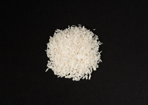 Grated coconut powder. Dry coco flakes pile, shredded desiccated coconut, tropical fruit chips