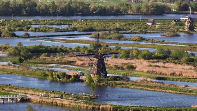 Traditional dutch windmills rotating in kinderdijk polder landscape