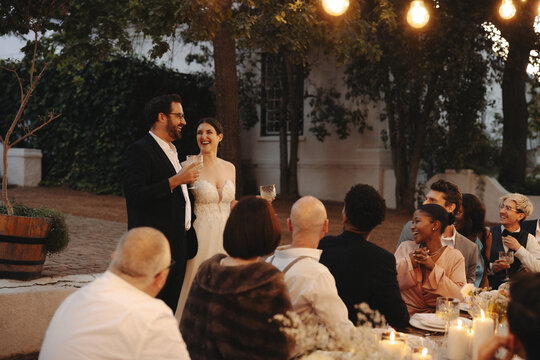 Bride and groom celebrate with guests during a garden wedding reception