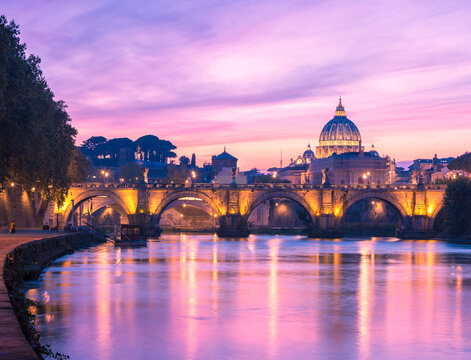 Scenic view from the Tiber on Ponte Sant'Angelo and St. Peter's Basilica in the twilight,  Rome, Italy.