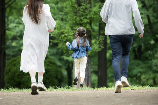 家族、新緑の公園で走る、かけっこする幸せなファミリーライフスタイル　全身の顔無しの後ろ姿