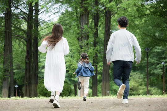 家族、新緑の公園で走る、かけっこする幸せなファミリーライフスタイル　全身の顔無しの後ろ姿
