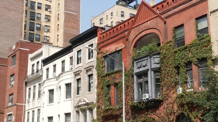Fototapeta premium New York City urban buildings architecture in residential district, Manhattan Upper West Side street, United States of America. Old historic classic red brick house in USA. Real estate property in NYC