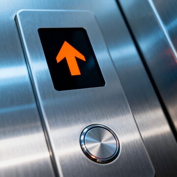 Close up of orange up arrow button