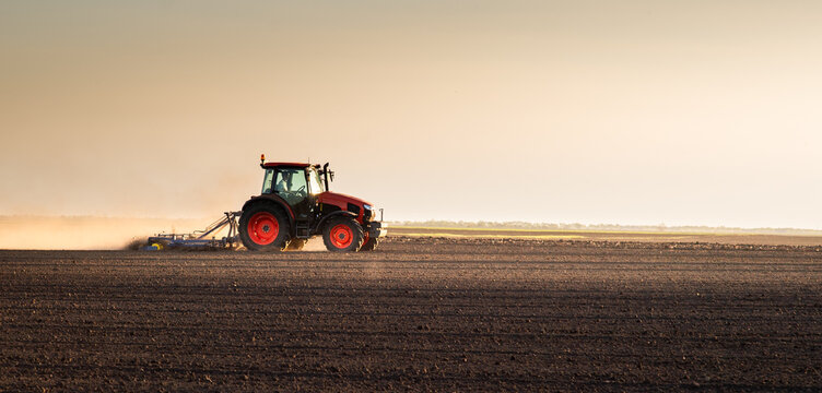 Farmer in tractor preparing land for sowing
