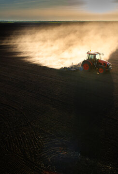 Farmer in tractor preparing land for sowing