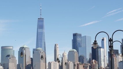Fototapeta premium New York City Manhattan Downtown Financial District skyline, World Trade Center tower from New Jersey Liberty state park, United States. Pier lantern lamps and urban cityscape, skyscraper buildings.