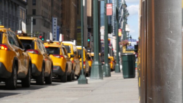 Manhattan Midtown street New York City, United States. Defocused row of yellow taxi cars. Many taxi cabs in line on 8th avenue near Penn Station. Taxi queue, urban road traffic, passenger transport.
