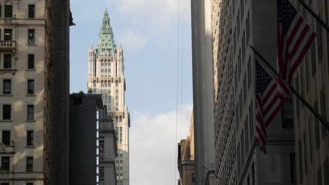 New York City Woolworth building 1913, skyscraper on Broadway in Downtown Financial District, Lower Manhattan, United States of America. Gothic historic architecture, cooper roof, USA american flag.