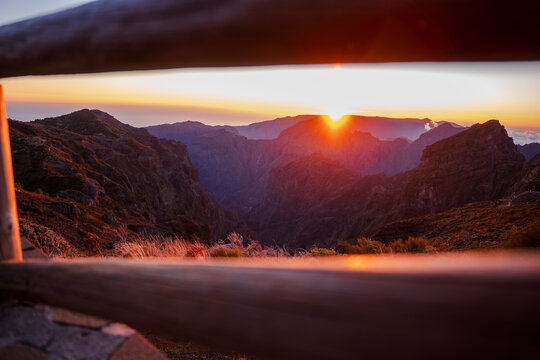 Sunrise over Pico do Arieiro and Pico Ruivo framed by fence rails