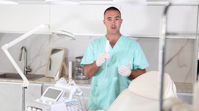 Male cosmetic doctor demonstrates Ultrasonic attachment of HydraFacial facial skin care machine for gentle skin treatment. High quality 4k footage