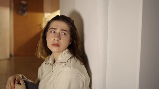 Woman sitting on floor at home after work feels exhausted leans against wall with closed eyes showing burnout low energy and mental fatigue caused by overload and constant daily stress