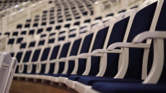 cinematic close-up of theater or concert hall seating, focusing on rows of elegant blue chairs with contrasting white armrests. empty concert hall, philharmonic. Moscow Russia 06.20.2025