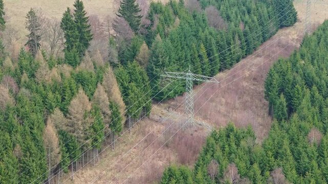 Electrical tower inspected from air by drone showing structure details and surroundings on mountain slope in early spring