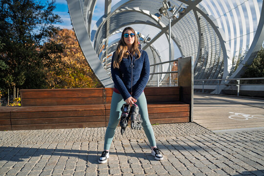 Woman holding rollerblades on arganzuela footbridge