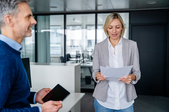 Business meeting in a modern office with two people discussing documents