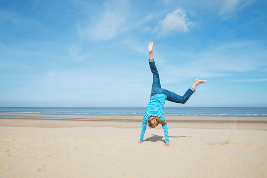 Carefree handstand on a sandy North Sea beach