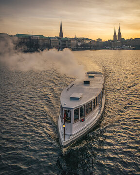 Old steamboat on Binnenalster lake in Hamburg at sunset