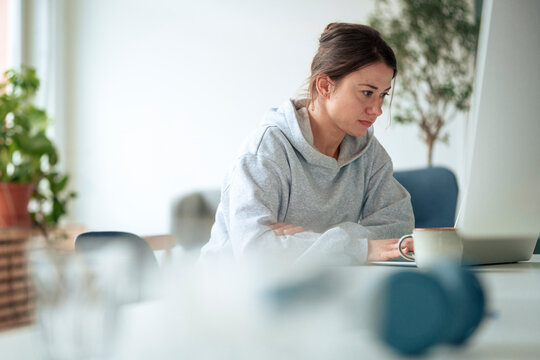 Confident businesswoman using laptop at table working from home