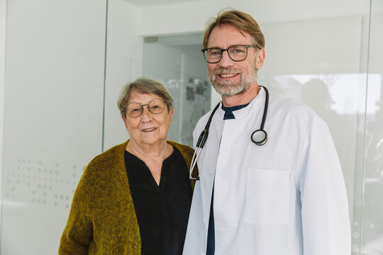 Smiling doctor and patient looking at camera in a clinic