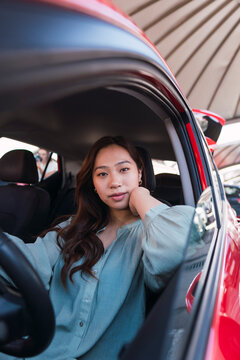 Young woman leaning on elbow sitting in car