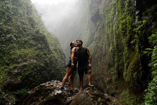 Couple kissing on a rock in the jungle of Java Indonesia