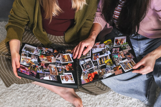 Friends looking at a photo album together indoors