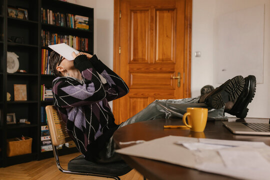 Stressed creative director resting feet on desk at the office