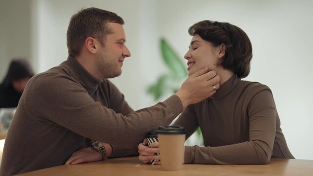Affectionate Couple Sharing a Romantic Moment and Coffee in a Cozy Cafe
