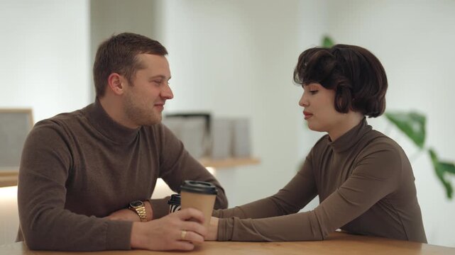 Happy Couple Enjoying a Relaxed Coffee Conversation in a Modern Cafe