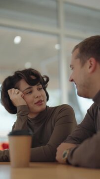 Young Couple Shares a Delightful Conversation Over Coffee in a Bright Cafe Setting