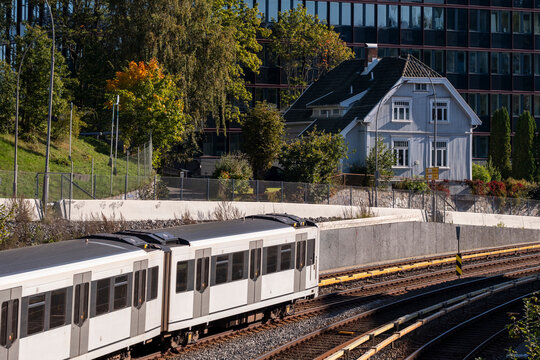 Urban mobility and transit rise in oslo where metro train runs on viaduct lines within cityscape transport infrastructure and modern housing