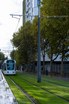 Urban mobility and transit in paris as tram and train share infrastructure on viaduct corridors creating a calm cityscape transport scene